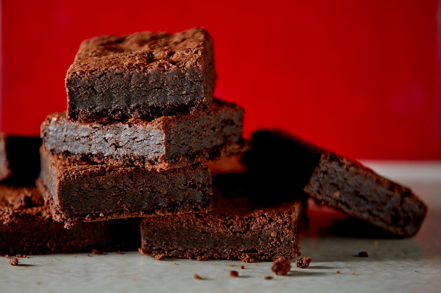 
                  
                    Close up of six stacked mouthwatering brownies in front of a stylish 12 piece brand box of brownies
                  
                
