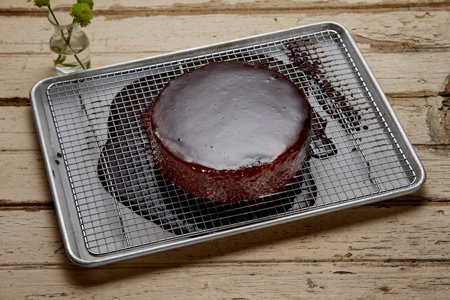 
                  
                    Glazed chocolate almond cake on a sheet tray on a rustic table top
                  
                