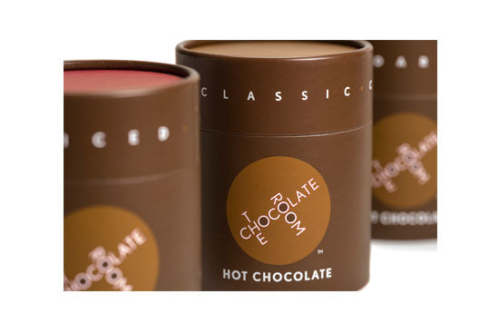 Classic, Dark , and Spiced Hot Chocolate powders in a stylish branded brown containers with a red top