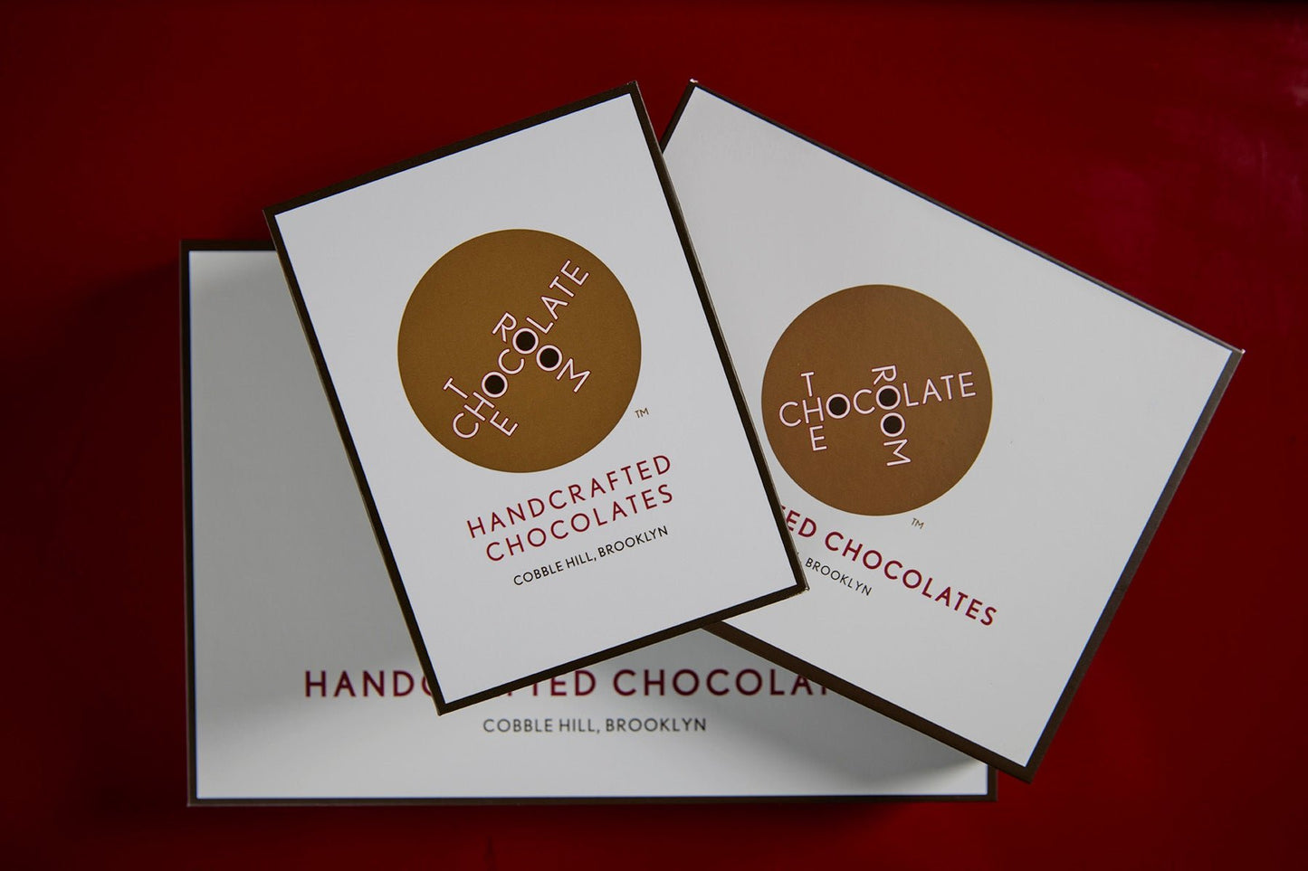 A stack of three elegantly branded The Chocolate Room bonbon boxes - 6, 12, and 24 piece.