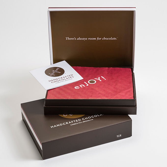 A stack of 2 12 piece bonbon boxes. Top on is open and say says There is always room for chocolate on the inside cover