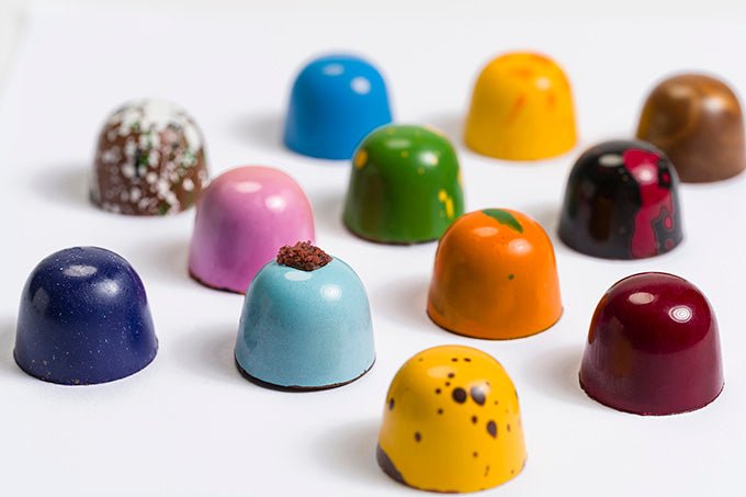 
                  
                    Close up view of 12 assorted colorful hand painted bonbons
                  
                