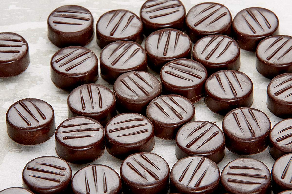 A close up of our peppermint patties on a parchment paper lined sheet tray