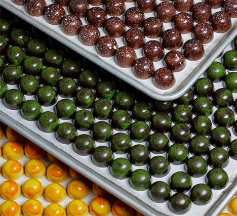 Three trays of multi-colored bonbons